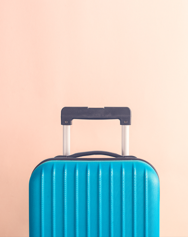 Blue suitcase over a pinkbackground, simplifying hotel subscription models