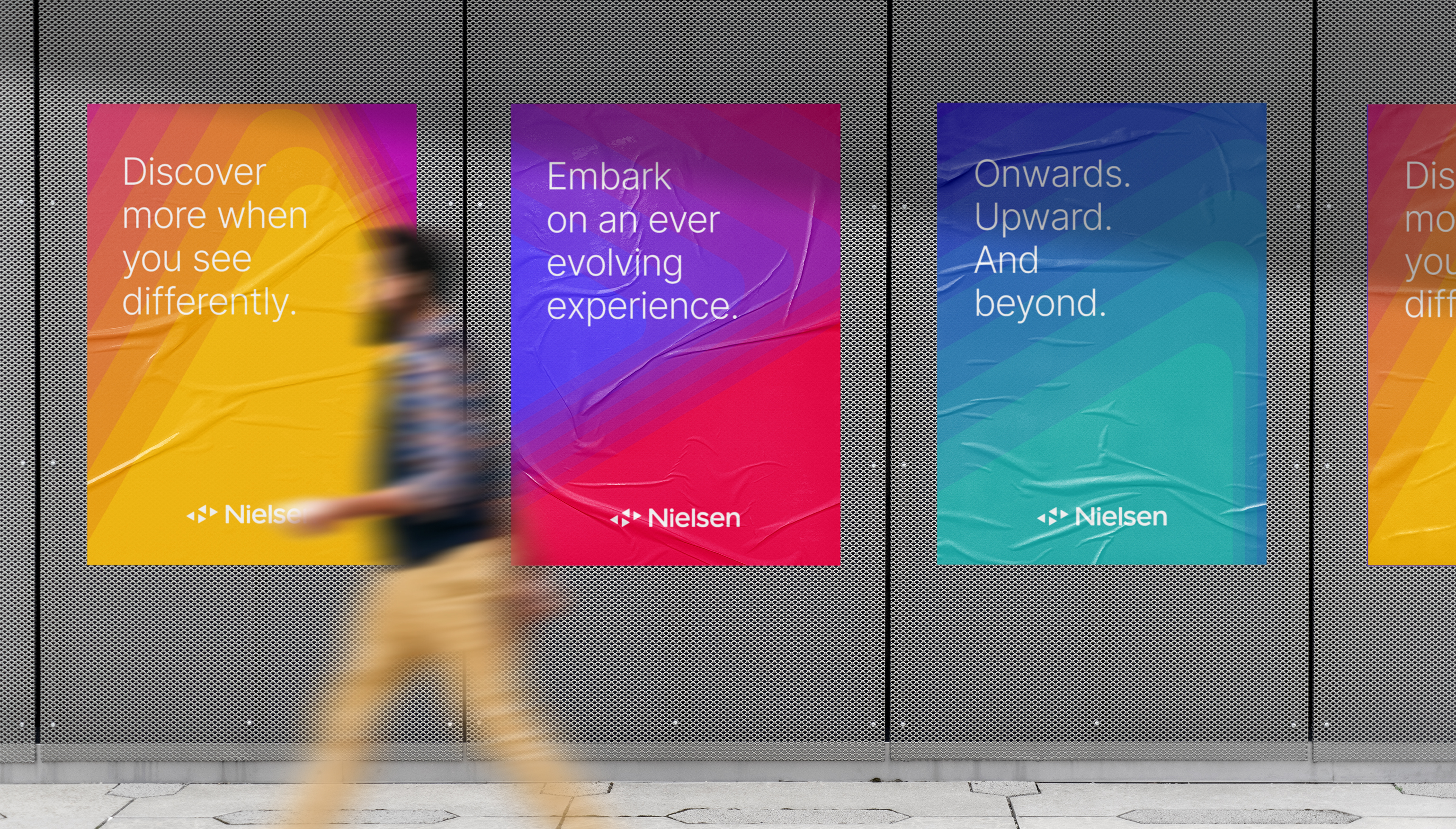 4 newly designed Nielsen posters on a wall in New York City showing new brand identity