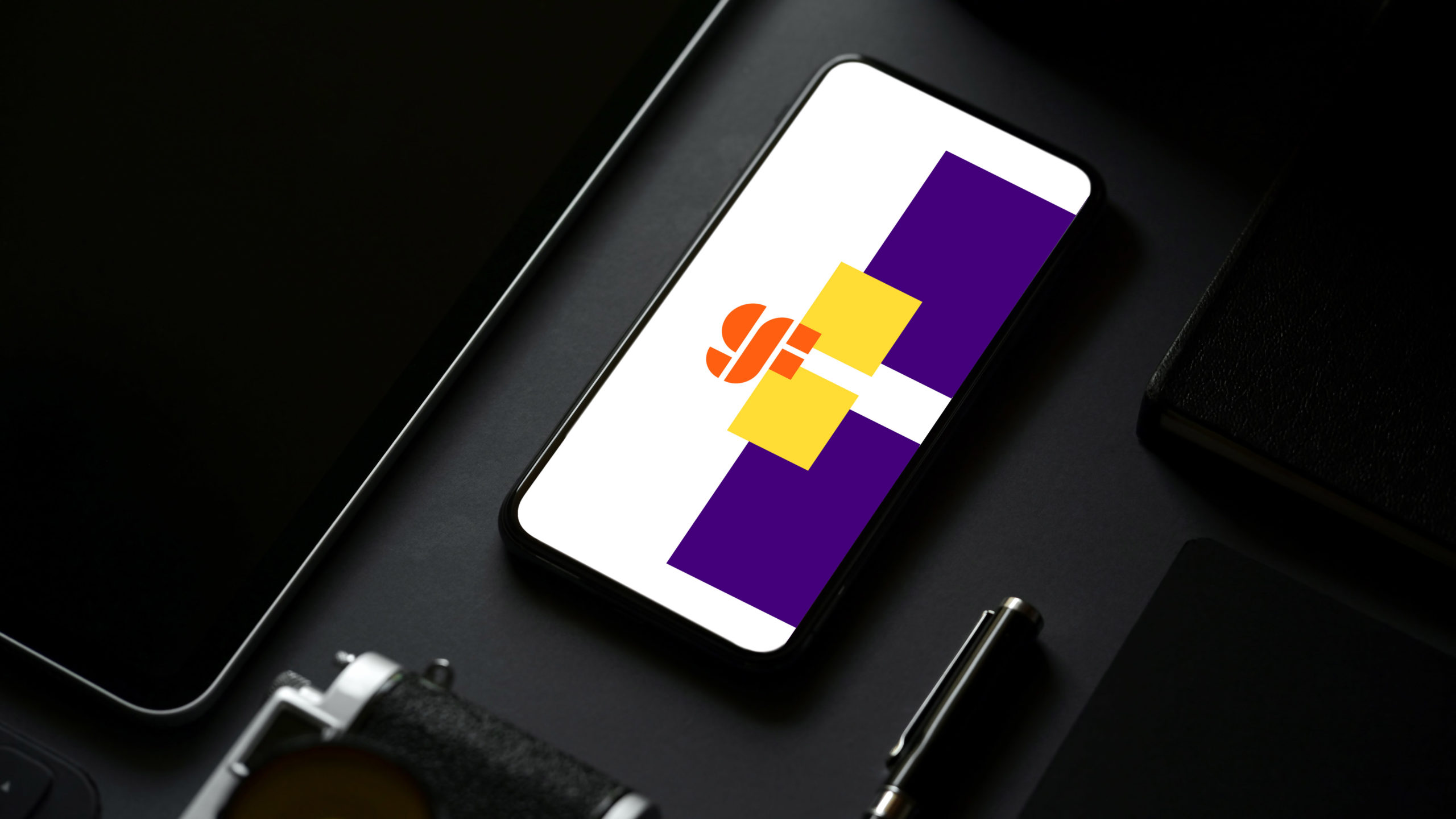 iPhone with Global Foundries new orange logo design over a white, yellow, and purple background