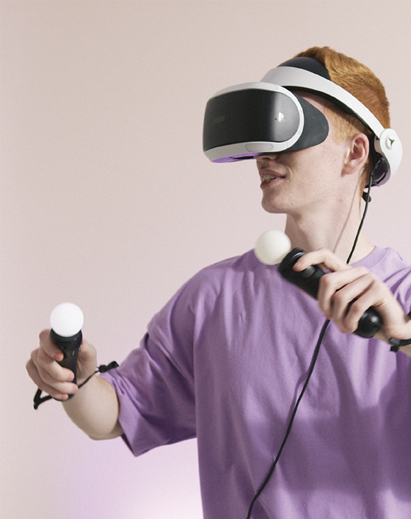 Gamer in a purple shirt using the playstation VR headset and remotes for an immersive brand experience